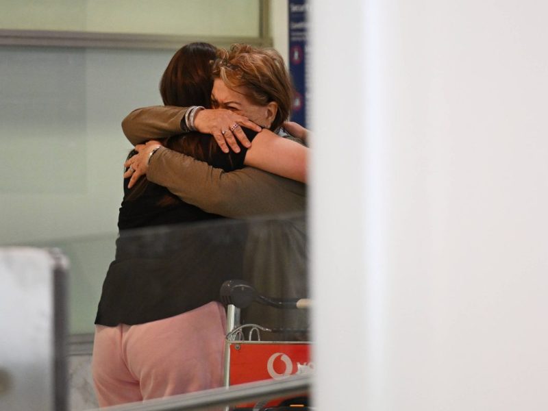 Symbolbild. Familie umarmt sich am Flughafen.