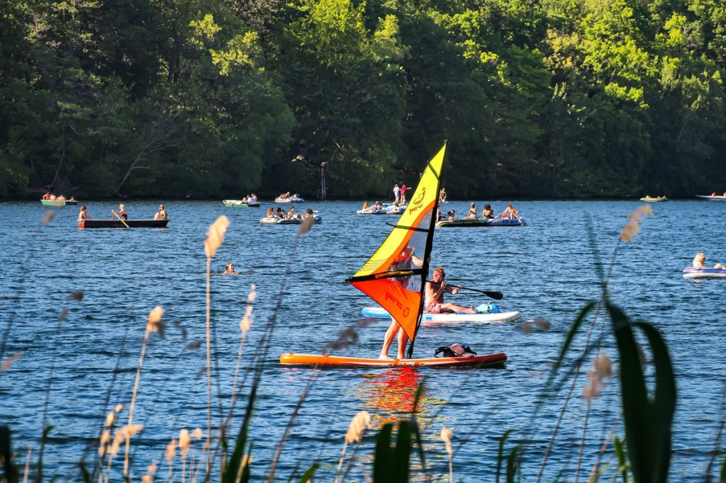 Menschen auf Segelbrettern auf dem See