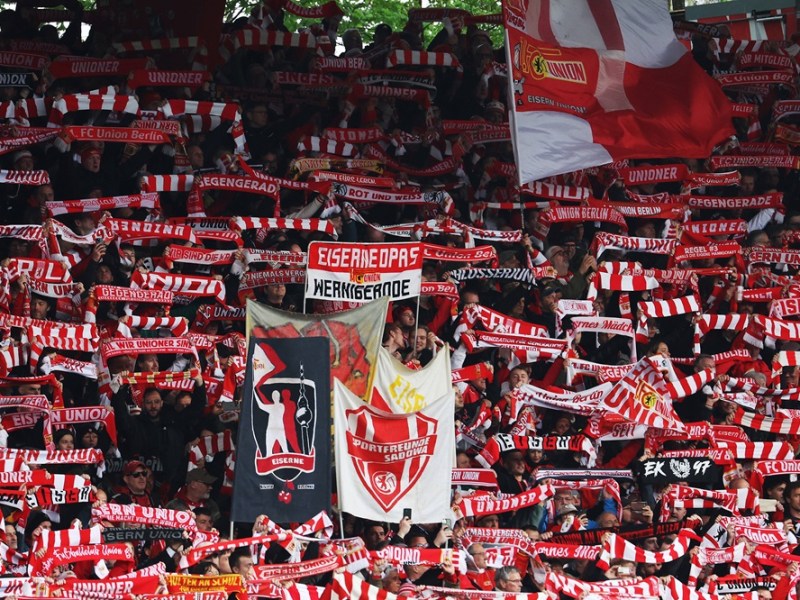 Die Fans von Union Berlin heben ihre Schals.